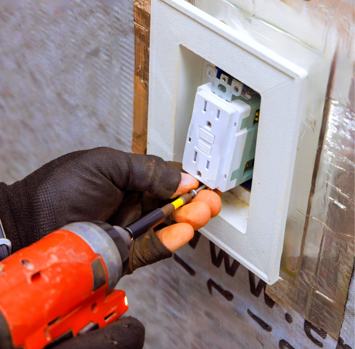 Gloved hands fixing wall socket